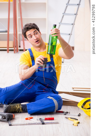 Floor repairman drinking alcohol during break 41299798