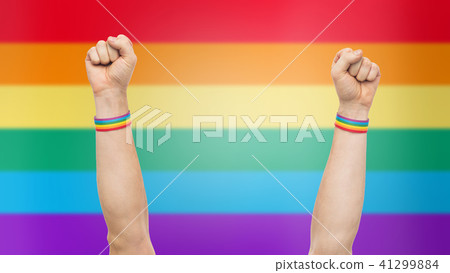 hands with gay pride rainbow wristbands shows fist 41299884