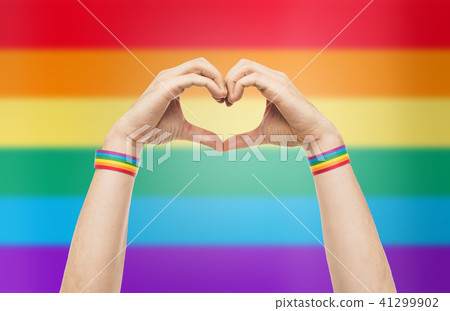 male hands with gay pride wristbands showing heart 41299902