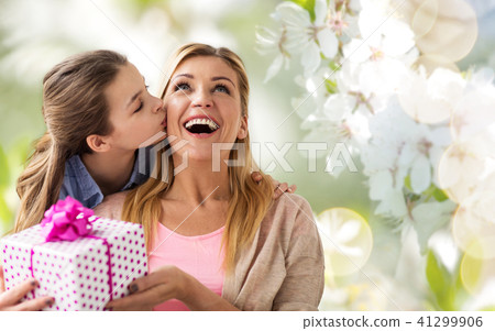 daughter kissing mother and giving her present daughter kissing mother and giving her present 41299906