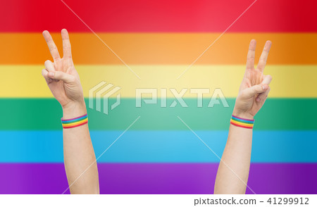 hands with gay pride rainbow wristbands make peace 41299912