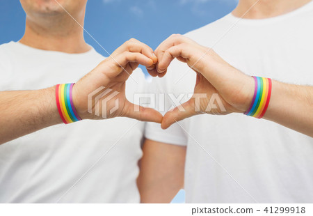 gay couple with rainbow wristbands and hand heart gay couple with rainbow wristbands and hand heart 41299918