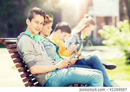 happy teenage boy with tablet pc and headphones happy teenage boy with tablet pc and headphones 41299987