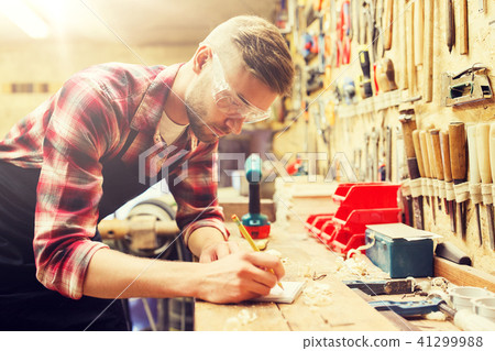 carpenter writing to notebook at workshop carpenter writing to notebook at workshop 41299988