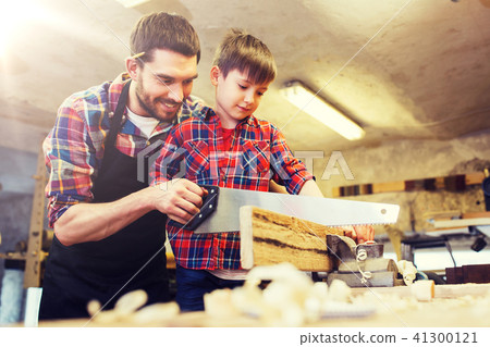 father and son with saw working at workshop 41300121