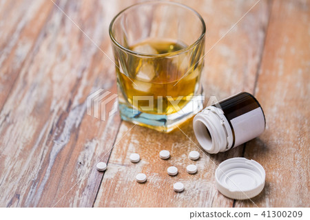 glass of alcohol and pills on table glass of alcohol and pills on table 41300209
