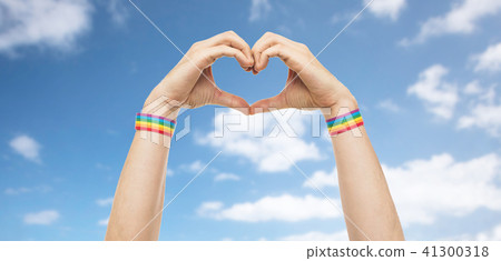 male hands with gay pride wristbands showing heart 41300318