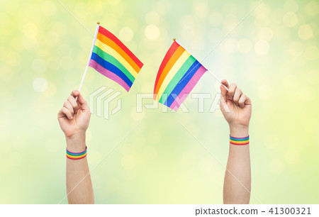 hand with gay pride rainbow flags and wristbands 41300321