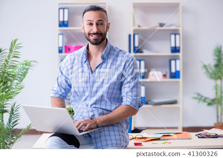 Young designer working in his studio on new project 41300326