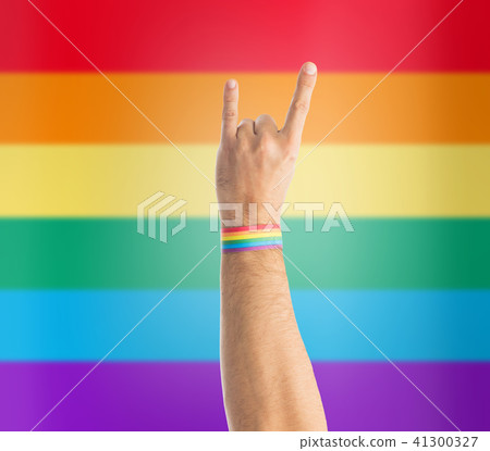 hand with gay pride rainbow wristband shows rock 41300327