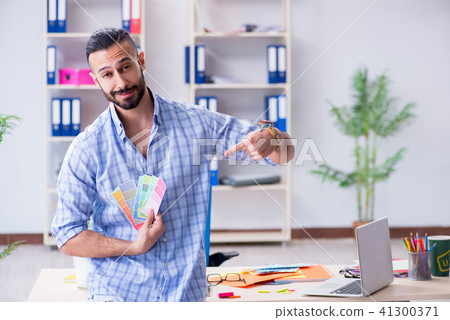 Young designer working in his studio on new project 41300371