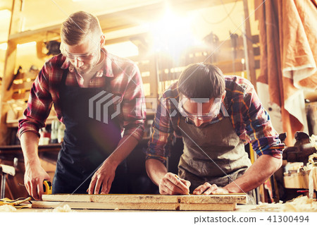 carpenters with ruler and wood plank at workshop carpenters with ruler and wood plank at workshop 41300494