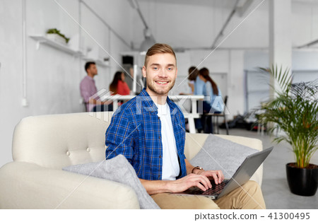 smiling man with laptop working at office smiling man with laptop working at office 41300495