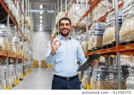 businessman with clipboard at warehouse showing ok 41300578