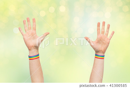 hands with gay pride rainbow wristbands 41300585