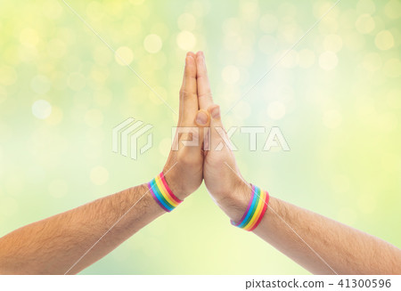 hands with gay pride wristbands make high five 41300596