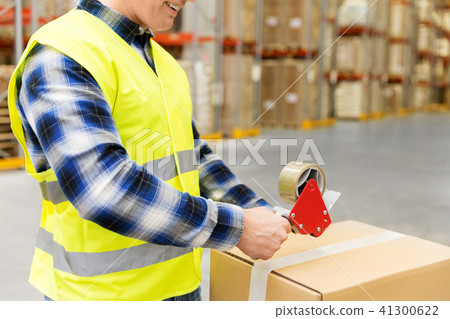 warehouse worker packing parcel with scotch tape warehouse worker packing parcel with scotch tape 41300622