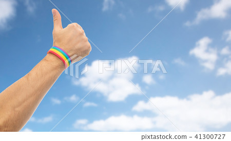 hand with gay pride rainbow wristband shows thumb 41300727