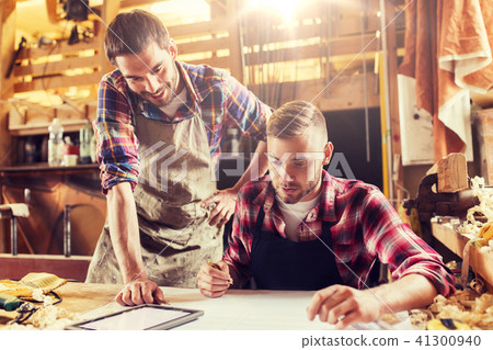 workmen with tablet pc and blueprint at workshop workmen with tablet pc and blueprint at workshop 41300940
