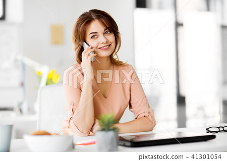 businesswoman calling on smartphone at office businesswoman calling on smartphone at office 41301054