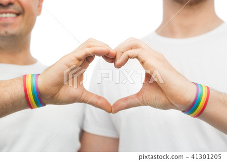 gay couple with rainbow wristbands and hand heart 41301205