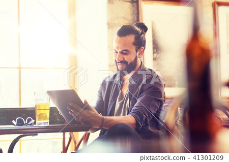 man with tablet pc drinking beer at bar or pub man with tablet pc drinking beer at bar or pub 41301209