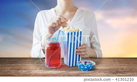woman eating popcorn with drink in glass mason jar 41301210