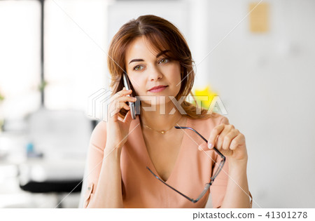 businesswoman calling on smartphone at office businesswoman calling on smartphone at office 41301278