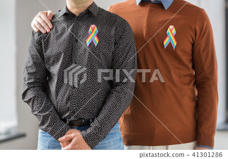 close up of couple with gay pride rainbow ribbons 41301286