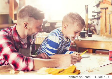 happy father and son with blueprint at workshop happy father and son with blueprint at workshop 41301404