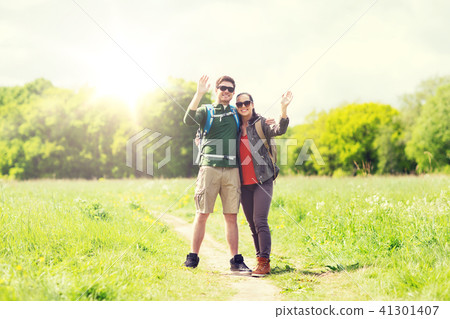 happy couple with backpacks hiking outdoors happy couple with backpacks hiking outdoors 41301407