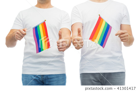 male couple with gay pride flags showing thumbs up 41301417