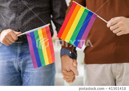 male couple with gay pride flags holding hands 41301418
