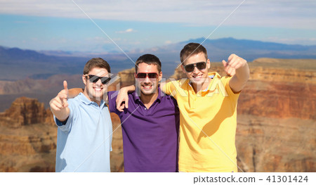 group of male friends hugging over grand canyon group of male friends hugging over grand canyon 41301424