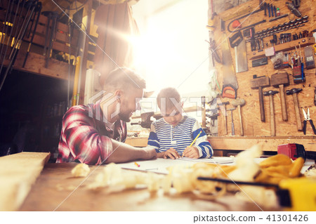 happy father and son with blueprint at workshop happy father and son with blueprint at workshop 41301426