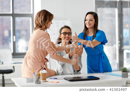 group of businesswomen showing thumbs up at office 41301497