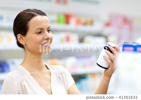 female customer choosing drugs at pharmacy 41301632