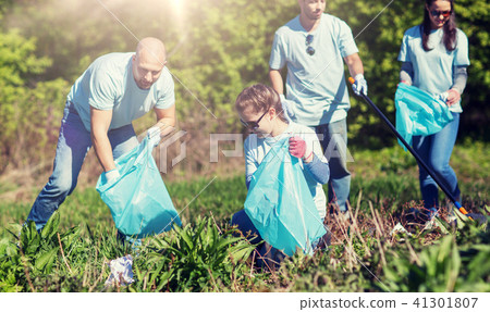 volunteers with garbage bags cleaning park area 41301807