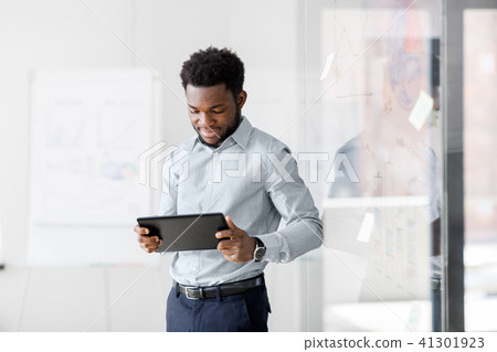 smiling businessman with tablet pc at office 41301923