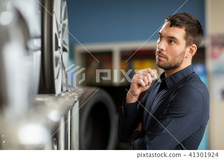 male customer choosing wheel rims at car service 41301924