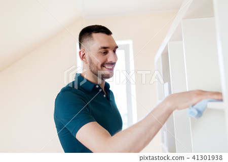 man cleaning shelf with cloth at home man cleaning shelf with cloth at home 41301938