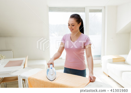 woman or housewife ironing towel by iron at home 41301980