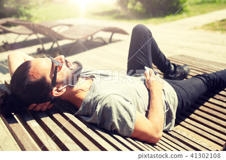 man with earphones and smartphone listening music man with earphones and smartphone listening music 41302108