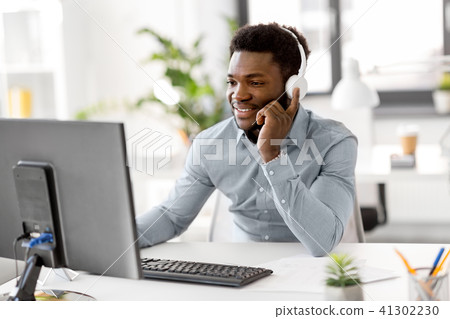businessman with headphones and computer at office businessman with headphones and computer at office 41302230