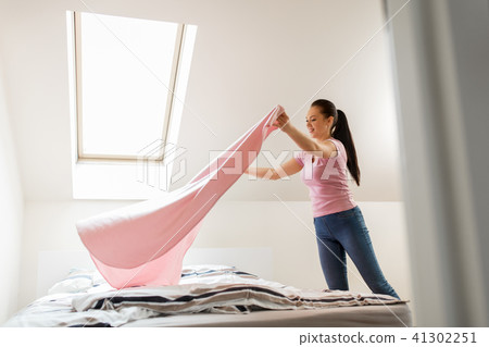 happy woman or housewife making bed at home happy woman or housewife making bed at home 41302251