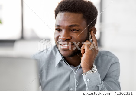 businessman with earphones and computer at office 41302331