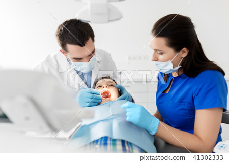 dentist checking for kid teeth at dental clinic 41302333