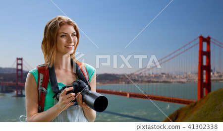 woman with backpack and camera over golden gate 41302338