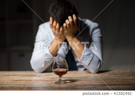 drunk man with glass of alcohol on table at night drunk man with glass of alcohol on table at night 41302492