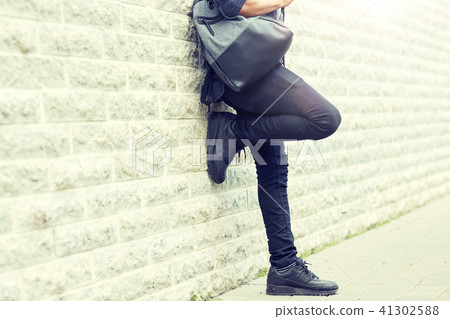 close up of man with backpack standing at wall 41302588